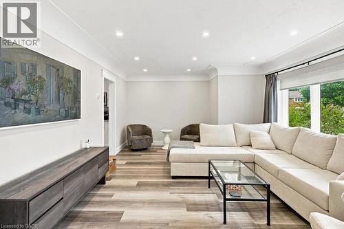 Spacious living area featuring wood-finish flooring, recessed lighting, crown molding, and a large window with roller shades - 67 Weber Street S, Waterloo, ON - Indoor Photo Showing Living Room