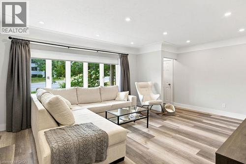 Spacious room featuring wood-finish flooring, recessed lighting, crown molding, and a large bay window - 67 Weber Street S, Waterloo, ON - Indoor Photo Showing Living Room