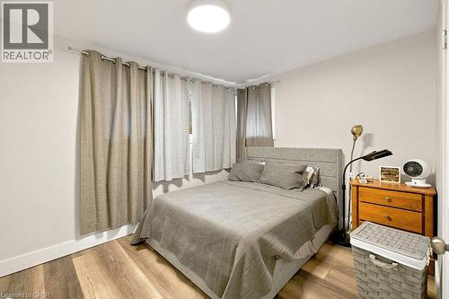 Bedroom featuring wood-finish flooring, a contemporary flush-mount ceiling light, and neutral wall tones - 67 Weber Street S, Waterloo, ON - Indoor Photo Showing Bedroom