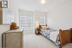 Bright room featuring two windows with horizontal blinds, neutral wall paint, and light-colored carpet flooring - 