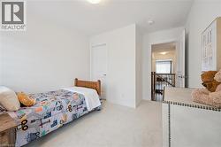 Carpeted room with a white door, white baseboards, and a ceiling light fixture - 