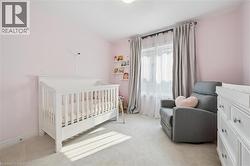 Bright room featuring a white crib and soft pink walls - 
