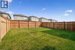 Expansive green lawn surrounded by a full-height wooden privacy fence - 
