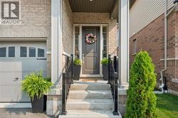 Brick facade entrance featuring a dark gray door with sidelights, white trim, and a covered porch - 