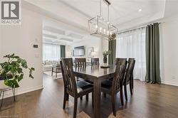 Dining area featuring a modern linear chandelier, wood-finish flooring, and crown molding - 