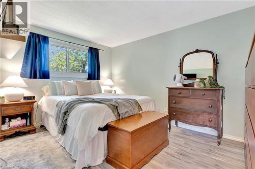 Light blue wall paint creating a serene atmosphere, complemented by light wood-finish flooring - 98 Belwood Crescent, Kitchener, ON - Indoor Photo Showing Bedroom