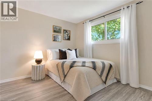 Bright room featuring a large window with ample natural light, wood-finish flooring, and light-toned walls - 98 Belwood Crescent, Kitchener, ON - Indoor Photo Showing Bedroom