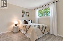 Bright room featuring a large window with ample natural light, wood-finish flooring, and light-toned walls - 