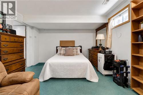Carpeted room with a built-in window, wood-finish shelving unit, and a doorway - 98 Belwood Crescent, Kitchener, ON - Indoor Photo Showing Bedroom