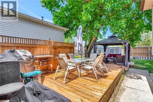Elevated wood-finish deck with a metal gazebo, mature shade tree, and privacy fencing - 98 Belwood Crescent, Kitchener, ON - Outdoor With Deck Patio Veranda
