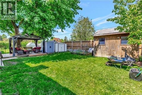 Expansive grassy lawn complemented by a wood deck with a covered gazebo, mature trees, a wood privacy fence, and a separate wood shed - 98 Belwood Crescent, Kitchener, ON - Outdoor