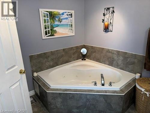 Corner jetted tub with tile surround and deck-mounted fixtures - 102 Willow Lane, Grimsby, ON - Indoor Photo Showing Bathroom