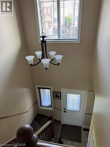 Two-story entryway featuring a decorative chandelier with five frosted glass shades - 102 Willow Lane, Grimsby, ON - Indoor Photo Showing Other Room