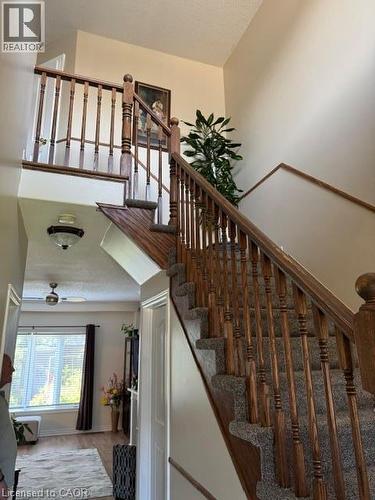 Carpeted staircase with wood-finish handrails and banister - 102 Willow Lane, Grimsby, ON - Indoor Photo Showing Other Room