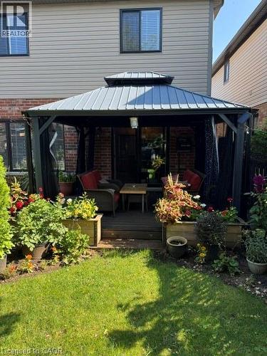 Backyard patio featuring a large gazebo with a metal roof and dark privacy curtains - 102 Willow Lane, Grimsby, ON - Outdoor With Exterior