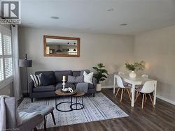 Open-concept living and dining area featuring wood-finish flooring, recessed lighting, and white plantation shutters - 