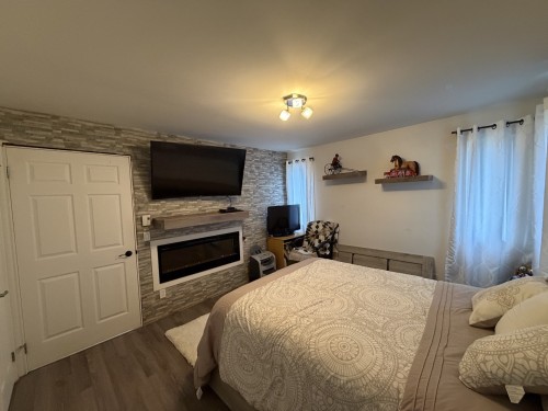 Chambre à coucher - 15 2E Avenue E., Paspébiac, QC - Indoor Photo Showing Bedroom With Fireplace