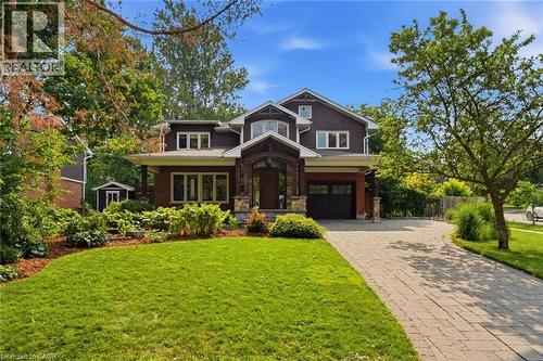 Craftsman-style residence featuring a prominent covered entry with stone accents, dark wood siding, and a paver driveway - 266 Ferndale Place, Waterloo, ON - Outdoor With Facade