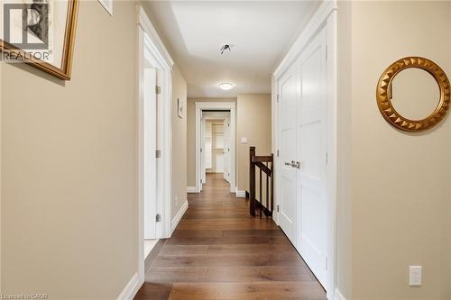 Hallway featuring wood-finish flooring, light tan wall color, white trim, and white paneled doors - 266 Ferndale Place, Waterloo, ON - Indoor Photo Showing Other Room