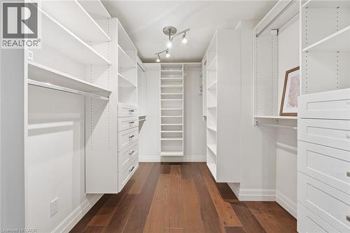 Custom closet system featuring wood-finish flooring, recessed lighting, built-in shelving, hanging rods, and multiple drawers - 266 Ferndale Place, Waterloo, ON - Indoor With Storage