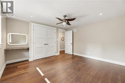 Spacious room featuring wood-finish flooring, a ceiling fan with integrated lighting, recessed lighting, and a built-in vanity with a stone countertop and illuminated mirror - 266 Ferndale Place, Waterloo, ON - Indoor Photo Showing Other Room
