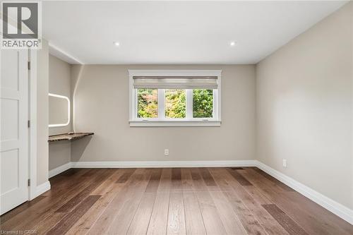 Hardwood flooring throughout, recessed ceiling lighting, and a built-in wood-finish desk with an illuminated mirror - 266 Ferndale Place, Waterloo, ON - Indoor Photo Showing Other Room