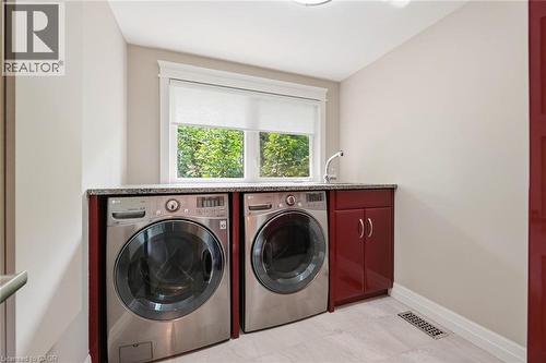 Dedicated laundry space featuring a granite-look countertop, integrated sink with faucet, white window treatments, and recessed lighting - 266 Ferndale Place, Waterloo, ON - Indoor Photo Showing Laundry Room