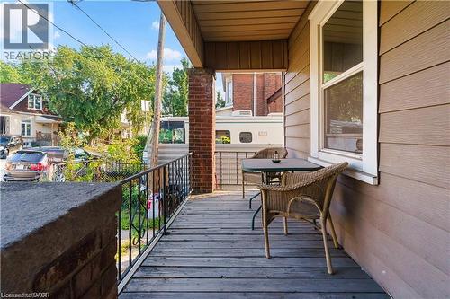 The property features a porch with wood decking and a black metal railing - 219 Avondale Street, Hamilton, ON - Outdoor With Exterior