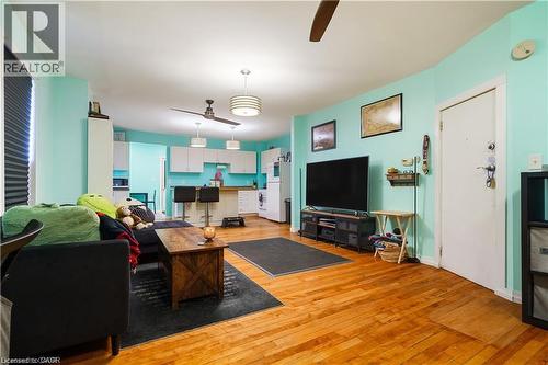 This open-concept living space features hardwood flooring, light blue walls, and a ceiling fan - 219 Avondale Street, Hamilton, ON - Indoor Photo Showing Living Room