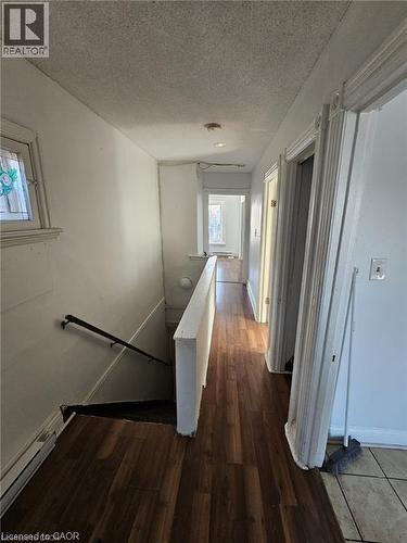 The property features a hallway with wood-look flooring and white painted walls, leading to additional rooms - 219 Avondale Street, Hamilton, ON - Indoor Photo Showing Other Room