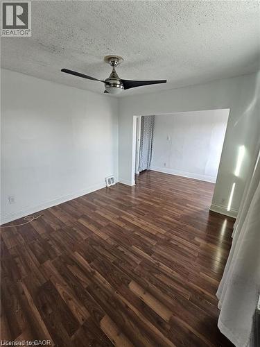 This room features dark wood-style flooring and a modern ceiling fan - 219 Avondale Street, Hamilton, ON - Indoor Photo Showing Other Room