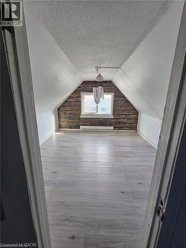 Versatile room featuring light-toned flooring, a window, and exposed wood paneling on one wall - 219 Avondale Street, Hamilton, ON - Indoor Photo Showing Other Room