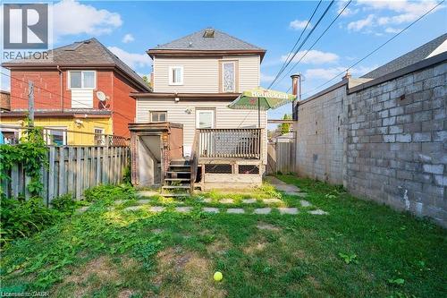 The property features a rear deck with access to the yard, which includes a lawn area and stepping stones - 219 Avondale Street, Hamilton, ON - Outdoor