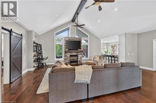Spacious living area featuring rich wood-finish flooring and vaulted ceilings with exposed beam accents - 2050 15 Side Road, Milton, ON - Indoor Photo Showing Living Room With Fireplace