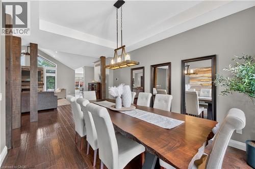 Dining area with wood-finish flooring, vaulted ceilings, and a rustic wood chandelier - 2050 15 Side Road, Milton, ON - Indoor Photo Showing Dining Room