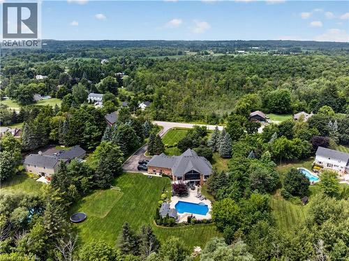 Expansive property featuring a brick exterior residence with a multi-level roofline, an in-ground swimming pool, and a large grassy yard with mature trees - 2050 15 Side Road, Milton, ON - Outdoor With View
