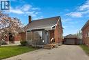 Brick and siding exterior featuring a detached garage, asphalt driveway, and a front porch with wood railings - 371 Ottawa Street S, Kitchener, ON  - Outdoor 