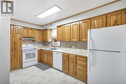 Kitchen featuring extensive natural wood cabinetry, light-toned countertops, and a patterned backsplash - 