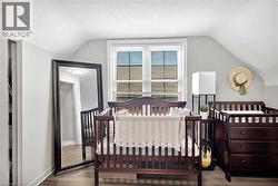 Room with sloped ceilings, light gray walls, white trim, and a window with horizontal blinds - 