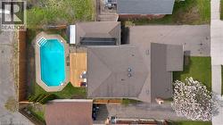 Backyard oasis featuring an in-ground swimming pool, surrounding concrete patio, and a wood deck - 