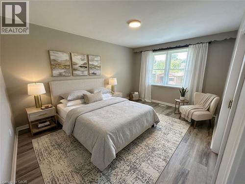 Bedroom featuring wood-finish flooring, a contemporary ceiling light fixture, and a large window with blinds - 20 Lloyd Manor Road, Etobicoke, ON - Indoor Photo Showing Bedroom