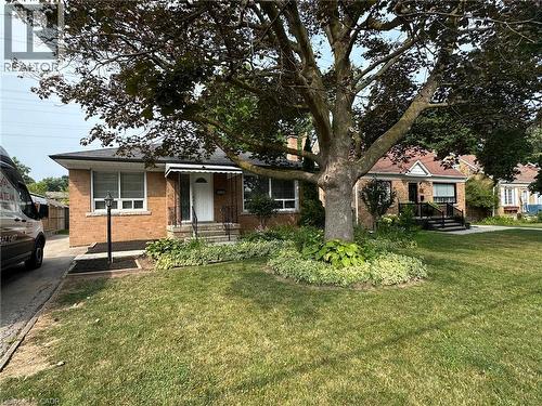 Brick facade residence featuring a front entry with a white awning, a lamp post, and a mature shade tree - 20 Lloyd Manor Road, Etobicoke, ON - Outdoor