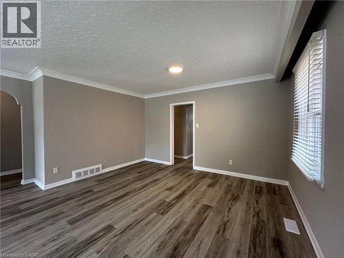 Spacious room featuring wood-finish flooring, neutral-toned walls, white crown molding, and a ceiling light fixture - 20 Lloyd Manor Road, Etobicoke, ON - Indoor Photo Showing Other Room