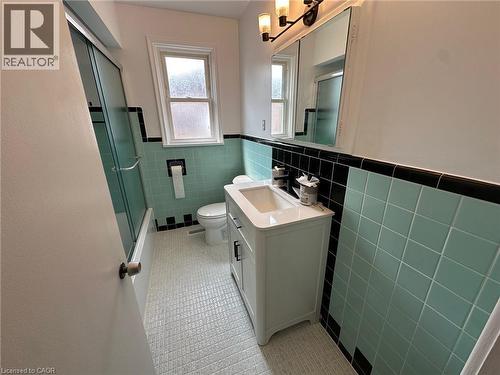 Full bathroom featuring a white vanity with white countertop, chrome fixtures, and a black-framed mirror with integrated lighting - 20 Lloyd Manor Road, Etobicoke, ON - Indoor Photo Showing Bathroom