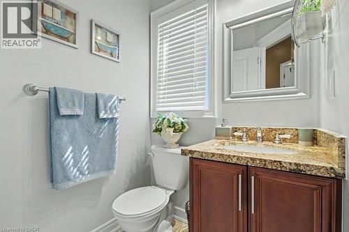 Bathroom featuring a dark wood-finish vanity with a granite countertop, undermount sink, and polished chrome faucet - 284 Normanhurst Avenue, Hamilton, ON - Indoor Photo Showing Bathroom