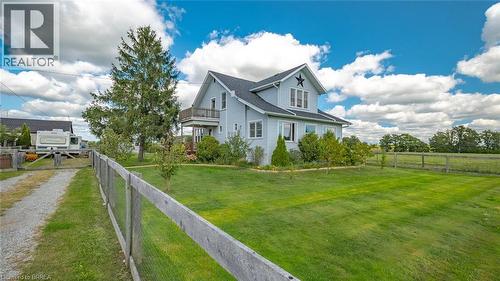 Light blue residence featuring a dark shingled roof and a decorative star accent - 3211 Highway 3, Jarvis, ON - Outdoor
