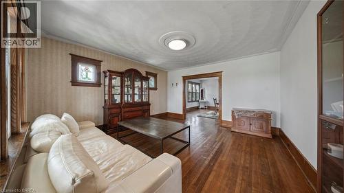 Spacious interior featuring hardwood flooring, detailed wood trim, decorative wall paneling, and an ornate ceiling medallion - 3211 Highway 3, Jarvis, ON - Indoor