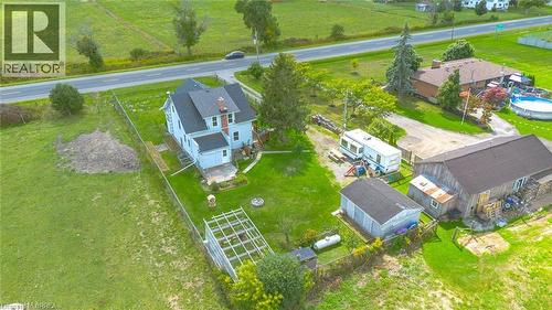 Expansive property with a light-colored two-story residence, featuring a dark-shingled roof and prominent chimney - 3211 Highway 3, Jarvis, ON - Outdoor With View
