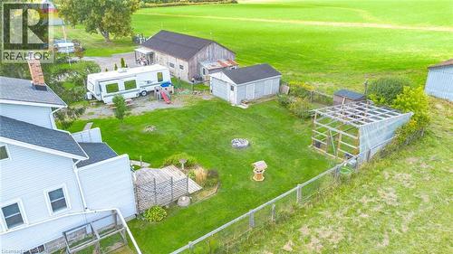 Expansive rear yard featuring a manicured lawn, multiple outbuildings, and a perimeter fence - 3211 Highway 3, Jarvis, ON - Outdoor