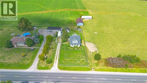 Aerial perspective highlighting a property with a primary residence, two outbuildings, and expansive surrounding green fields - 3211 Highway 3, Jarvis, ON - Outdoor With View